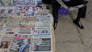 A Kenyan newspaper vendor reads a newspaper, Nairobi, Kenya, 10 November 2016 